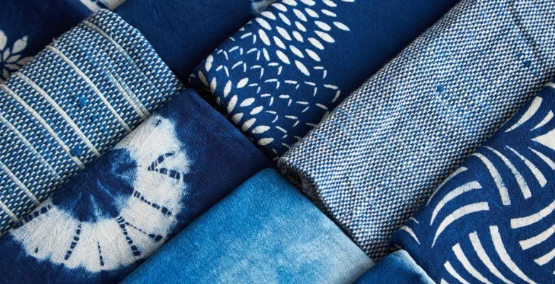 پارچه‌ها و پوشاک وارداتی در انبار مرزی ایران که نمادی از رشد قاچاق و تأثیر سیاست‌های تعرفه‌ای بر صنعت نساجی کشور است.