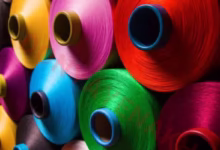 نمای نزدیک از نخها و الیاف پلیاستر در کارخانه نساجی