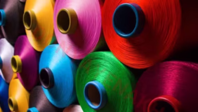 نمای نزدیک از نخ‌ها و الیاف پلی‌استر در کارخانه نساجی