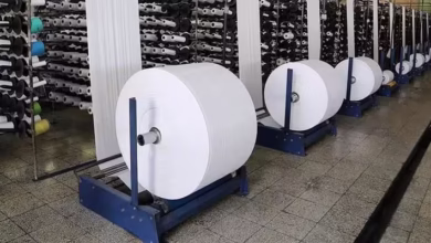 رول‌های پارچه خارجی انباشته در یک انبار مرزی بدون بسته‌بندی رسمی