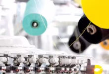 کارگران مشغول به کار با ماشین‌آلات قدیمی در کارخانه‌ای نساجی در ایران